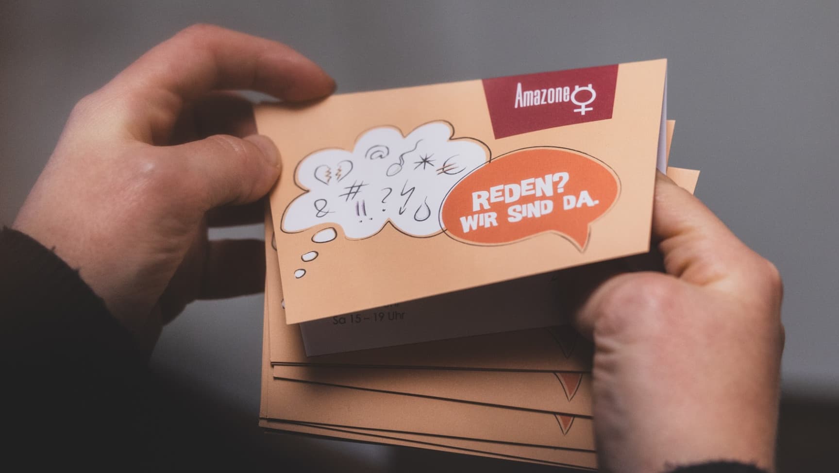 Hände halten den Beratungsflyer